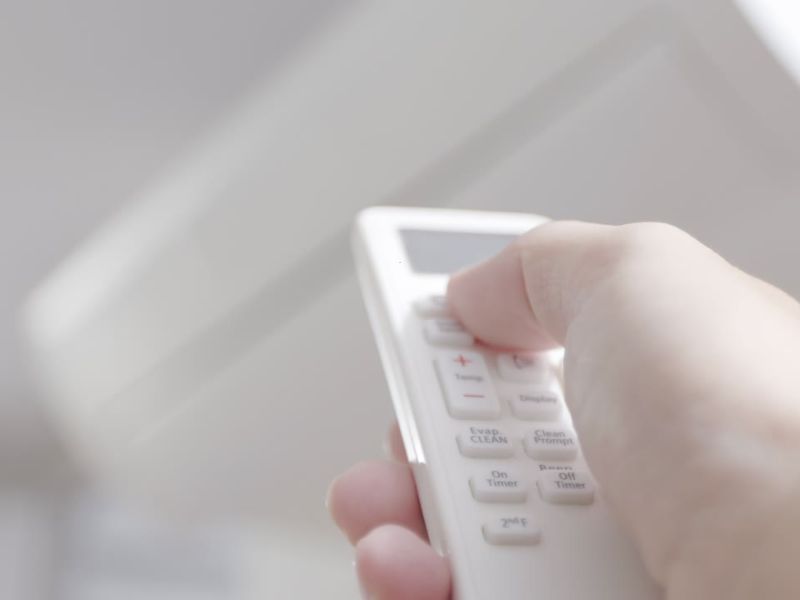 osoba koristi daljinski za klima uređaj