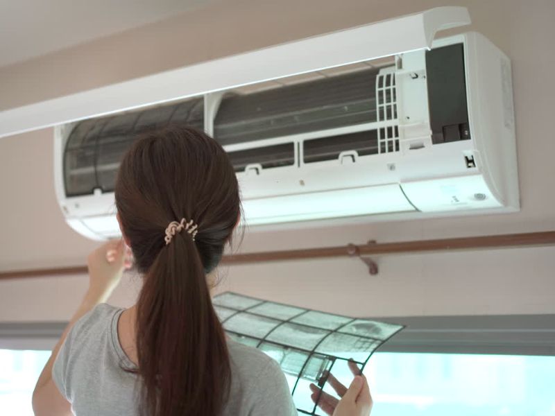 devojka vadi filtere iz klima uređaja